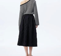 THEO the Label Calypso Plaid Box Pleat Midi Skirt in black - women's skirt - detail view
