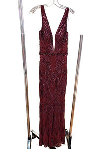 Maroon beaded evening gown on a hanger in a store setting